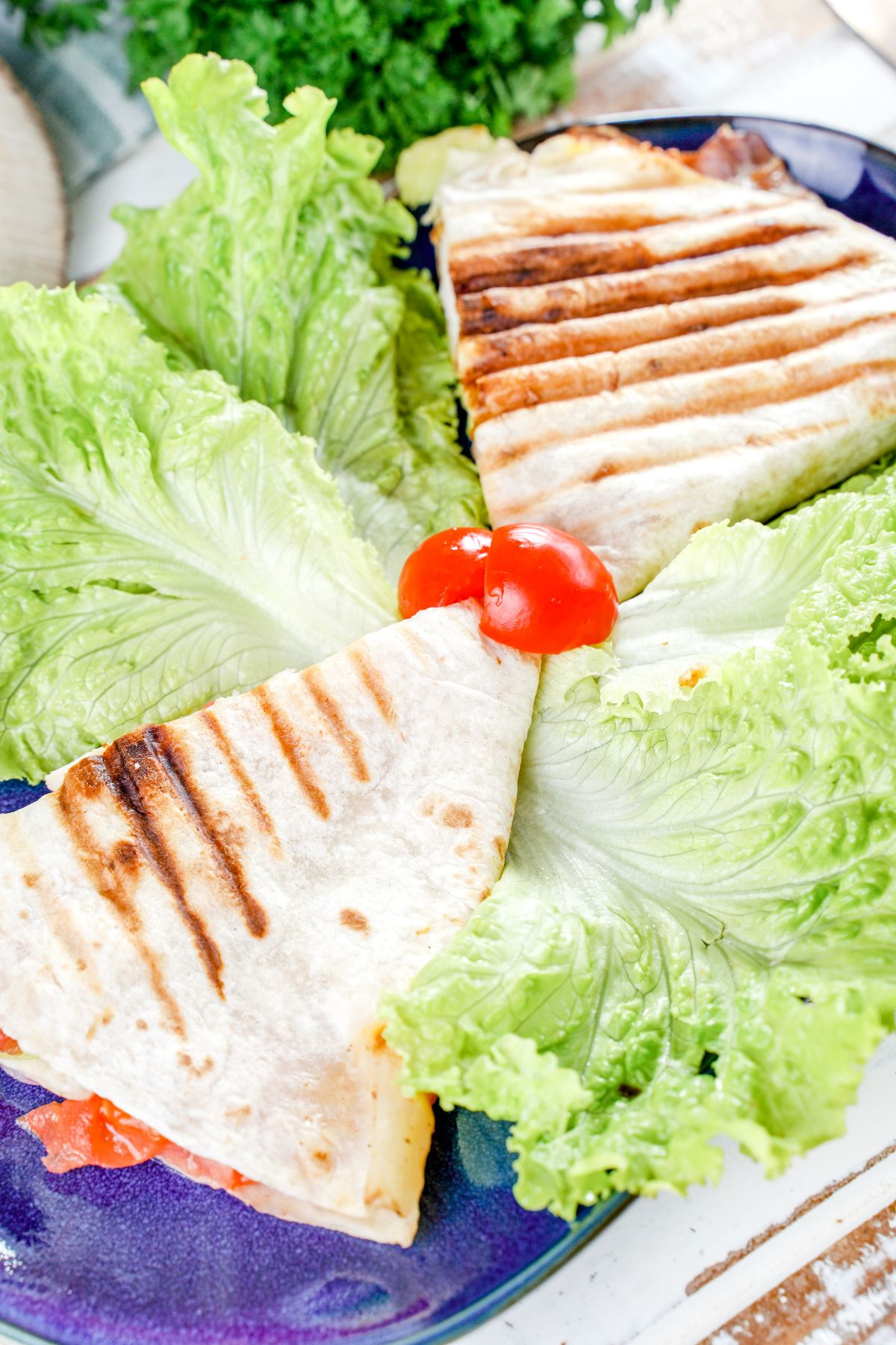 tortilla wrap on blue plate with lettuce leaves