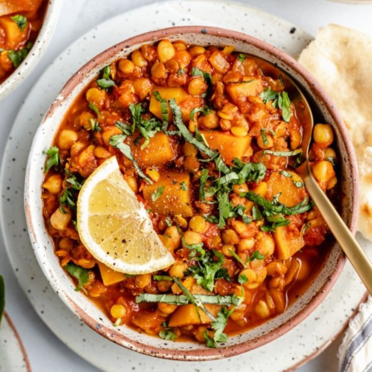 white bowl of chickpeas with herbs and lemon on top