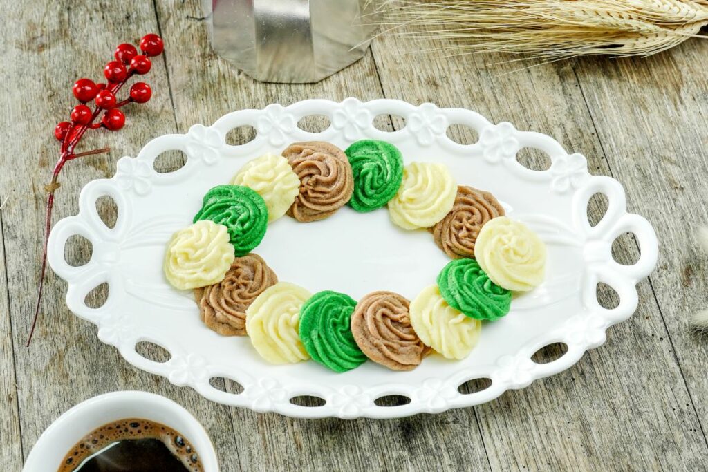 white platter with a ring of butter cookies on wood table