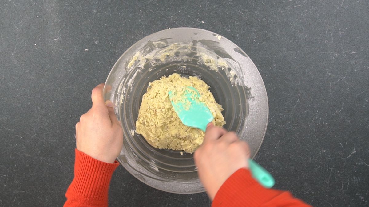 cookie dough in glass bowl with teal spatula on top