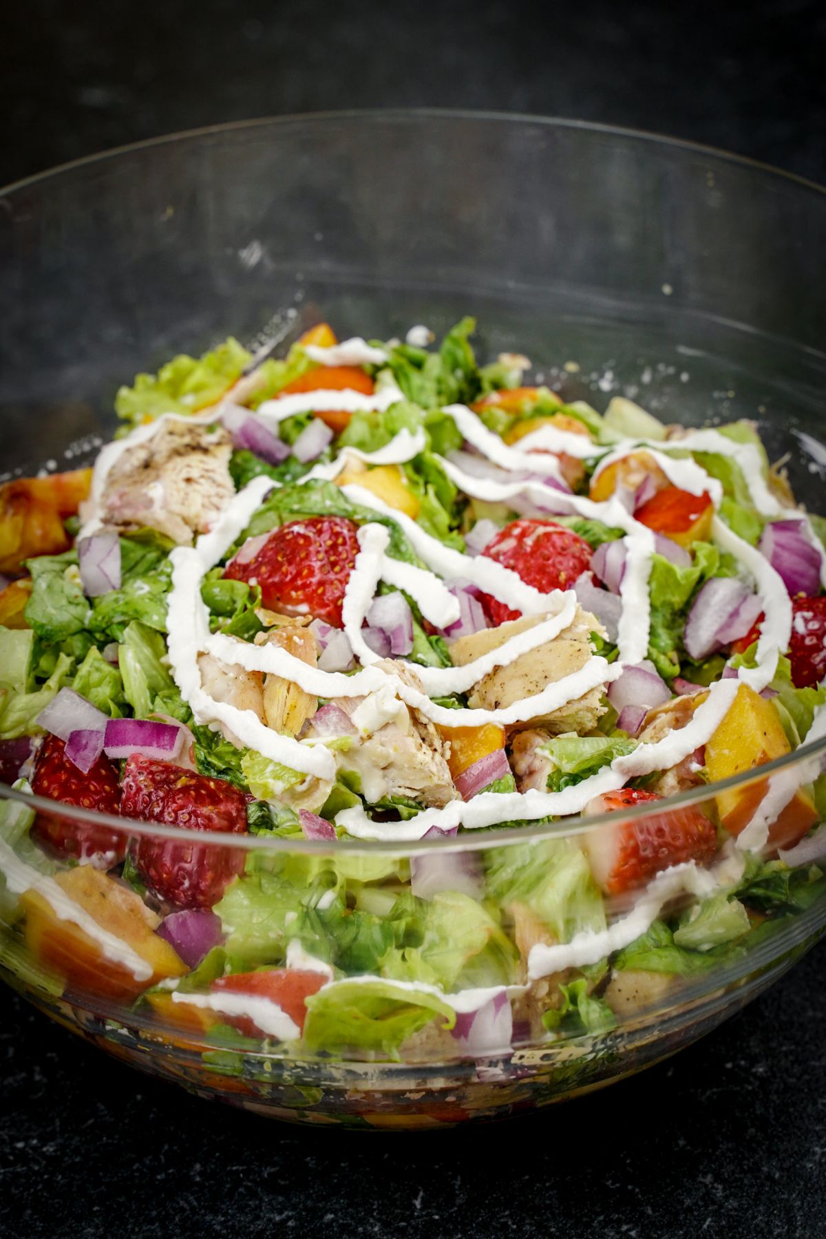 large glass bowl filled with salad chicken and fruit