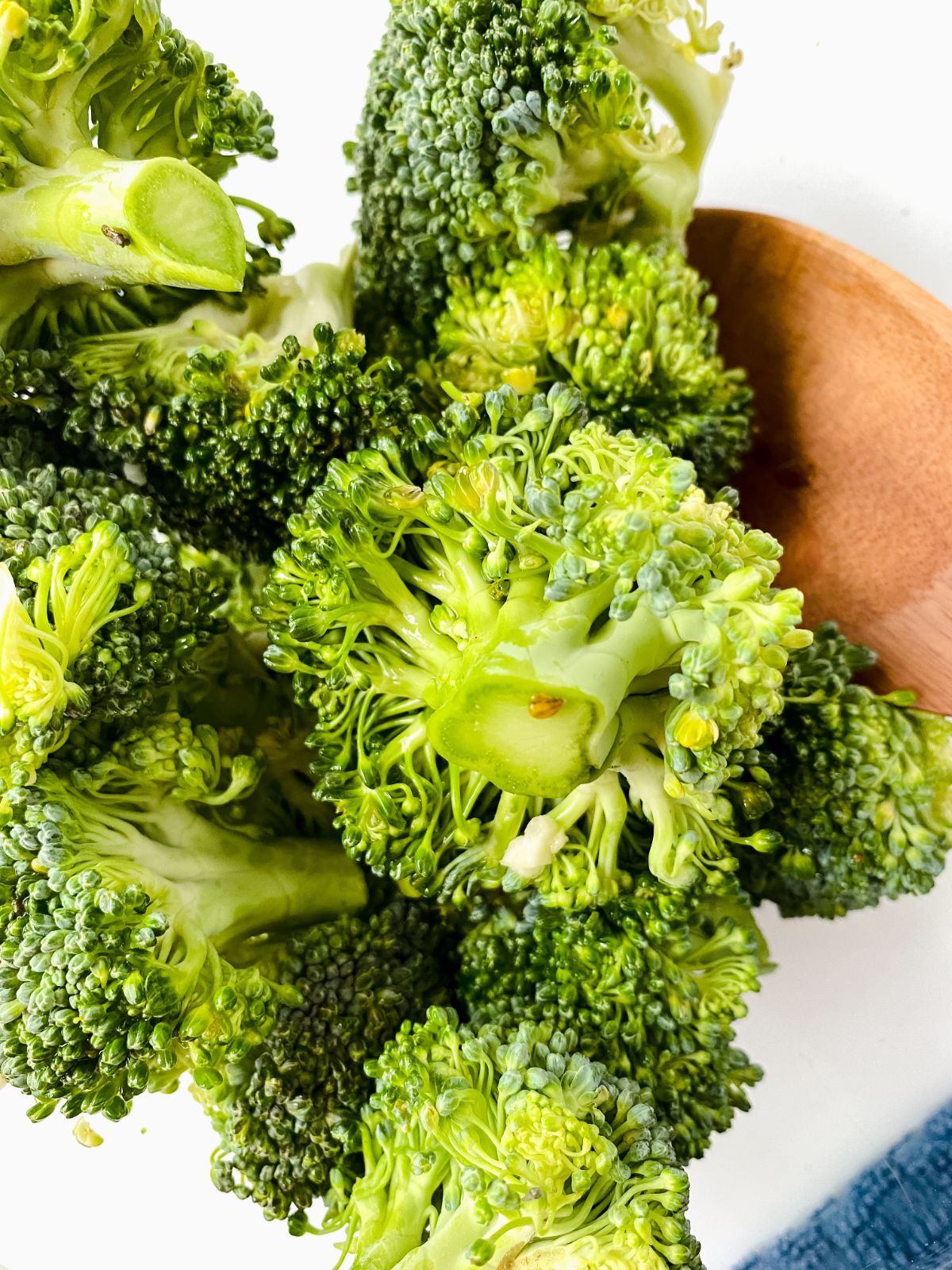 broccoli florets in bowl with wooden spoon