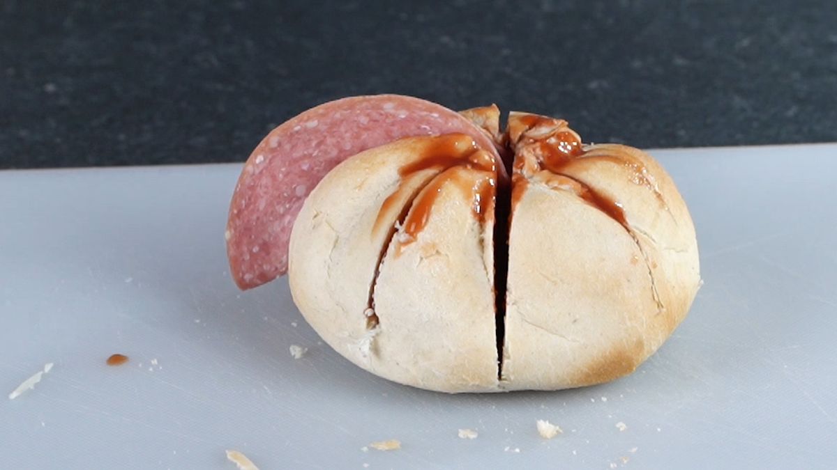 pepperoni being stuffed into bun
