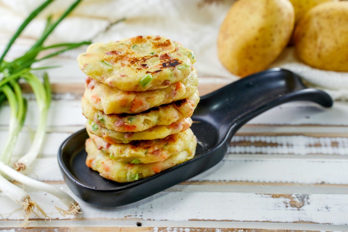 stack of potato cakes on black large spoon plate sitting on wood table
