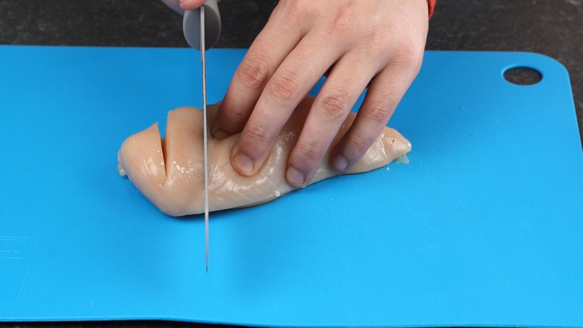 knife cutting into chicken breasts