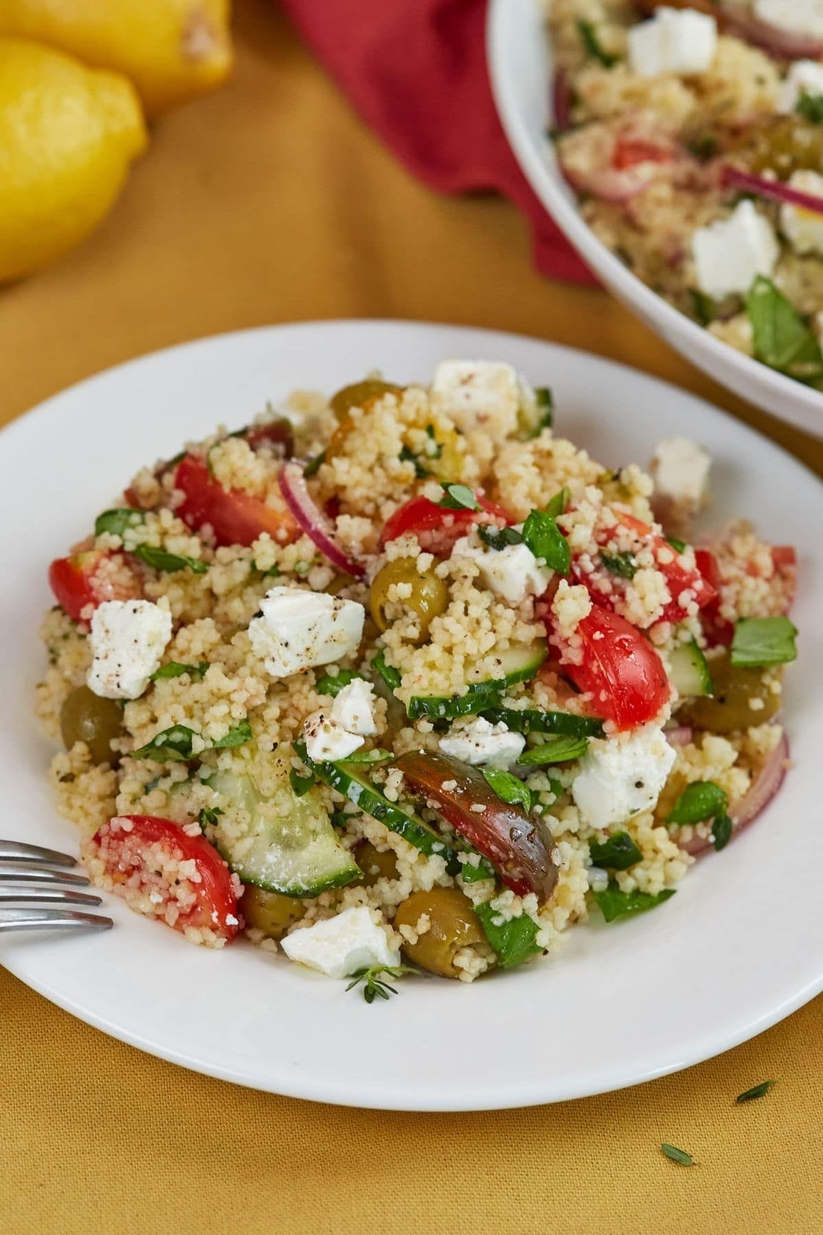 couscous in bowl with feta and tomato on table