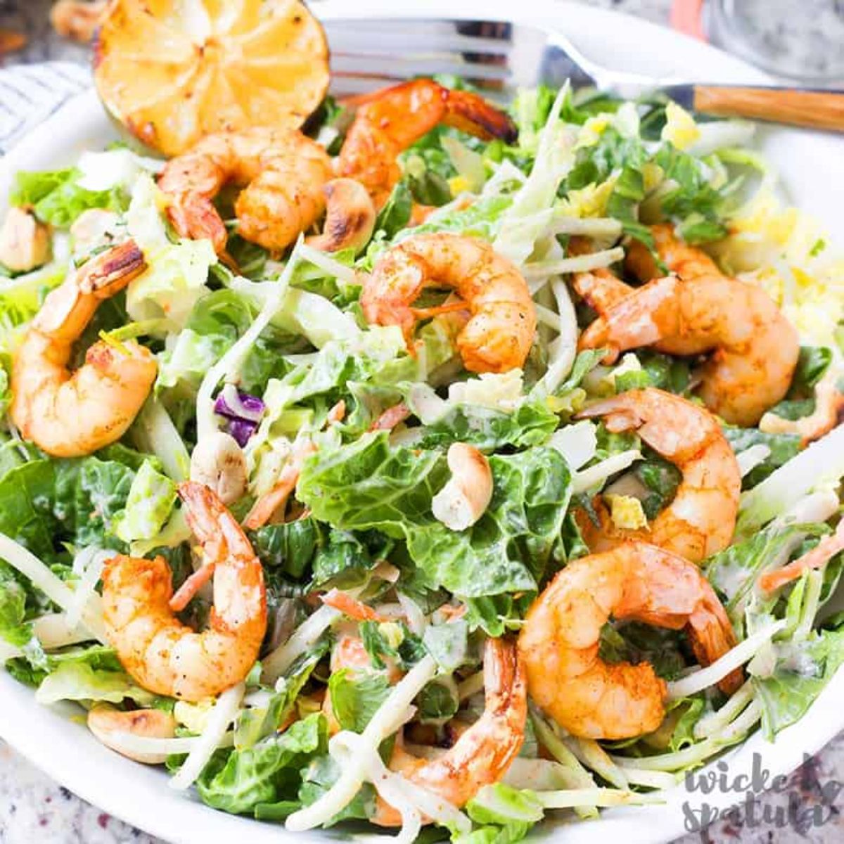shrimp on top of salad in white bowl