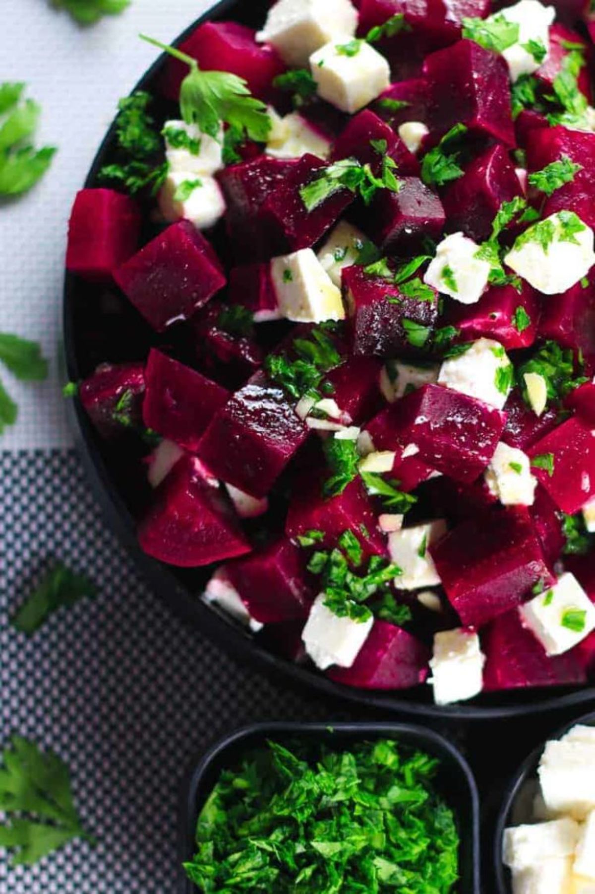 beets and feta cubes in large black bowl on blue table