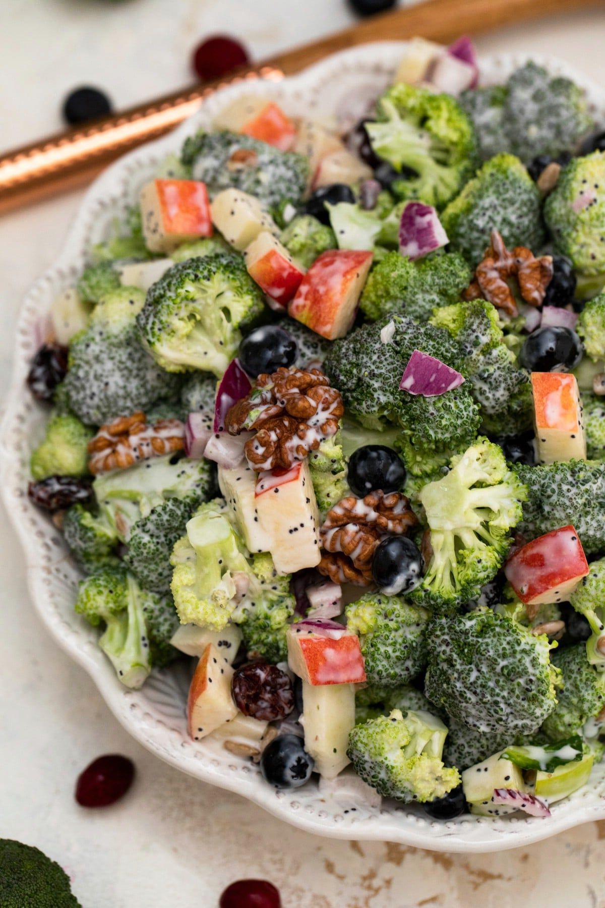 broccoli salad with apple chunks and nuts in large gray bowl