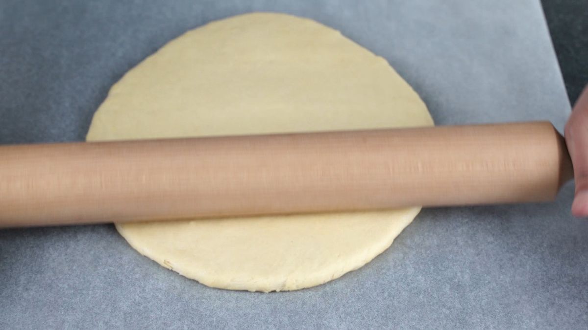 wood rolling pin on circle of dough