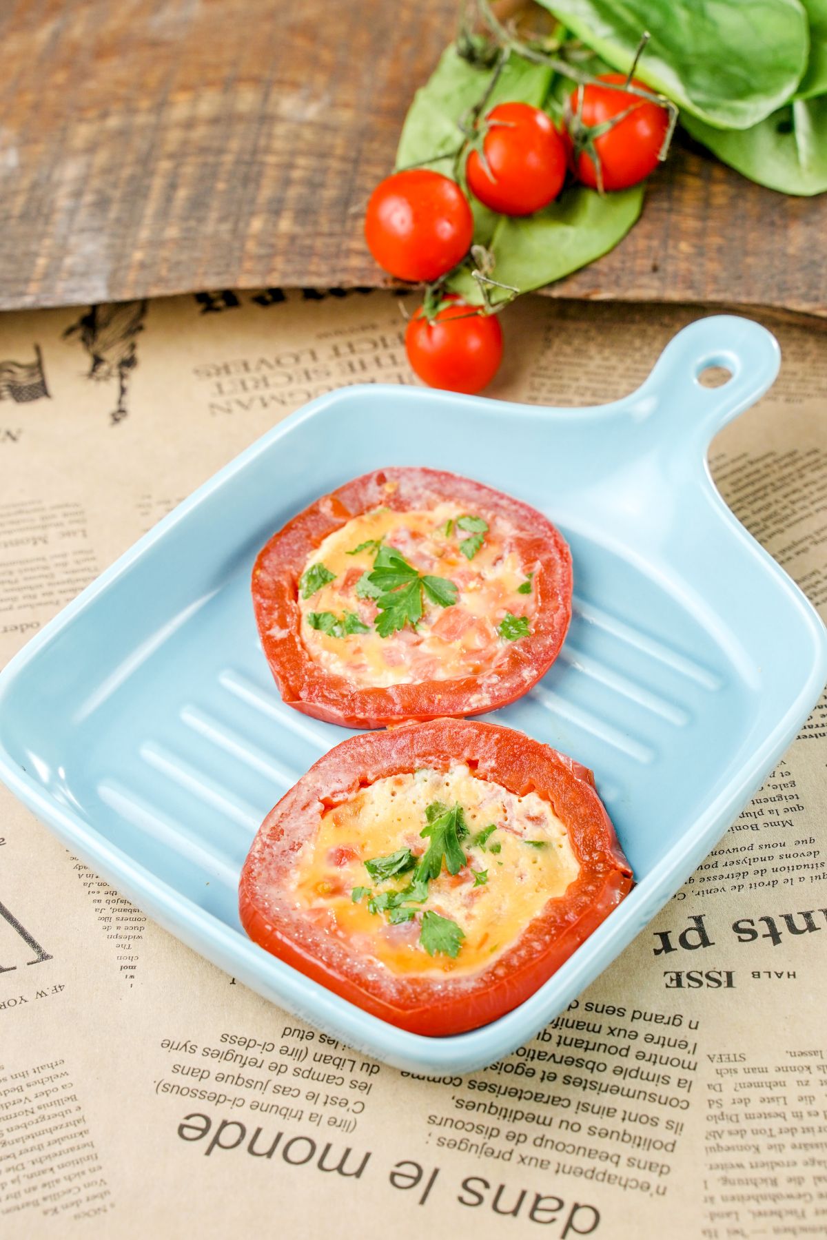 square blue grill pan on newspaper holding tomato egg slices