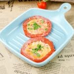 square blue grill pan on newspaper holding tomato egg slices
