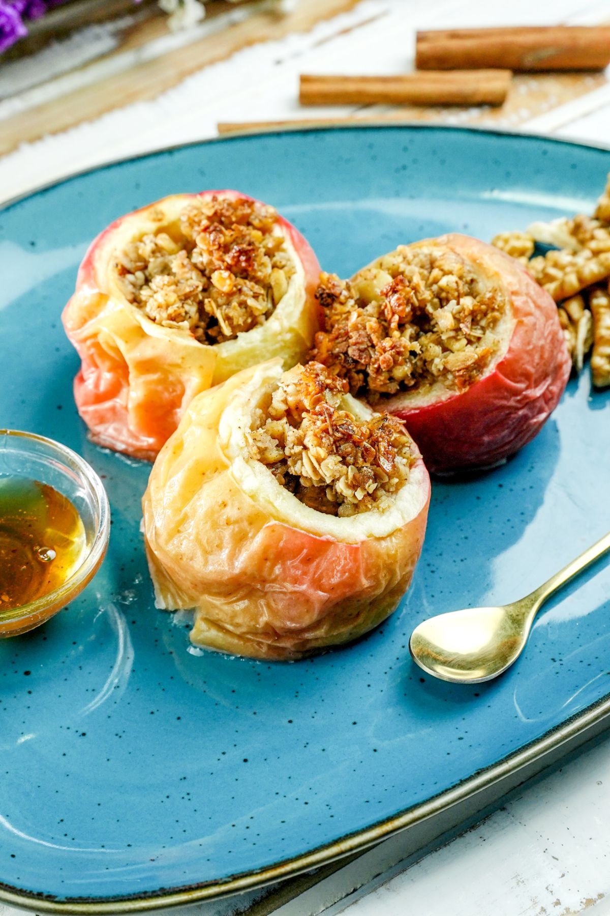 oval blue plate of stuffed apples with gold spoon