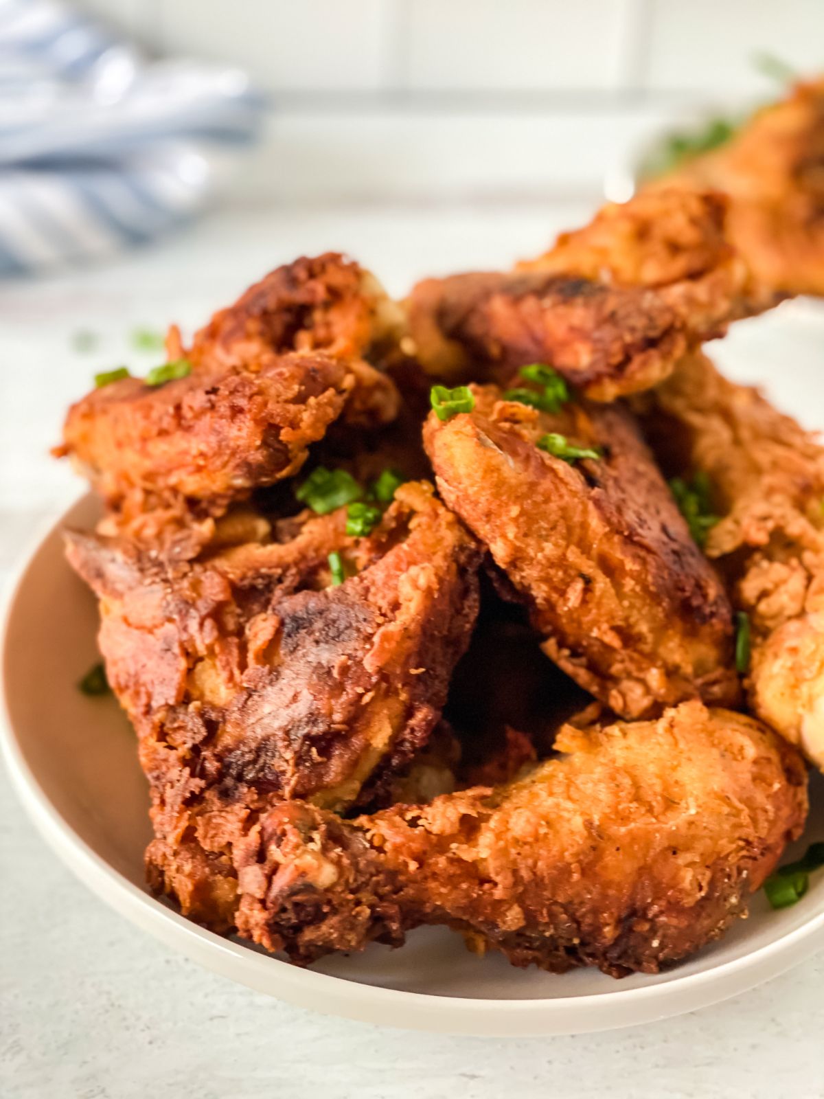 white bowl of fried chicken on table with tile background