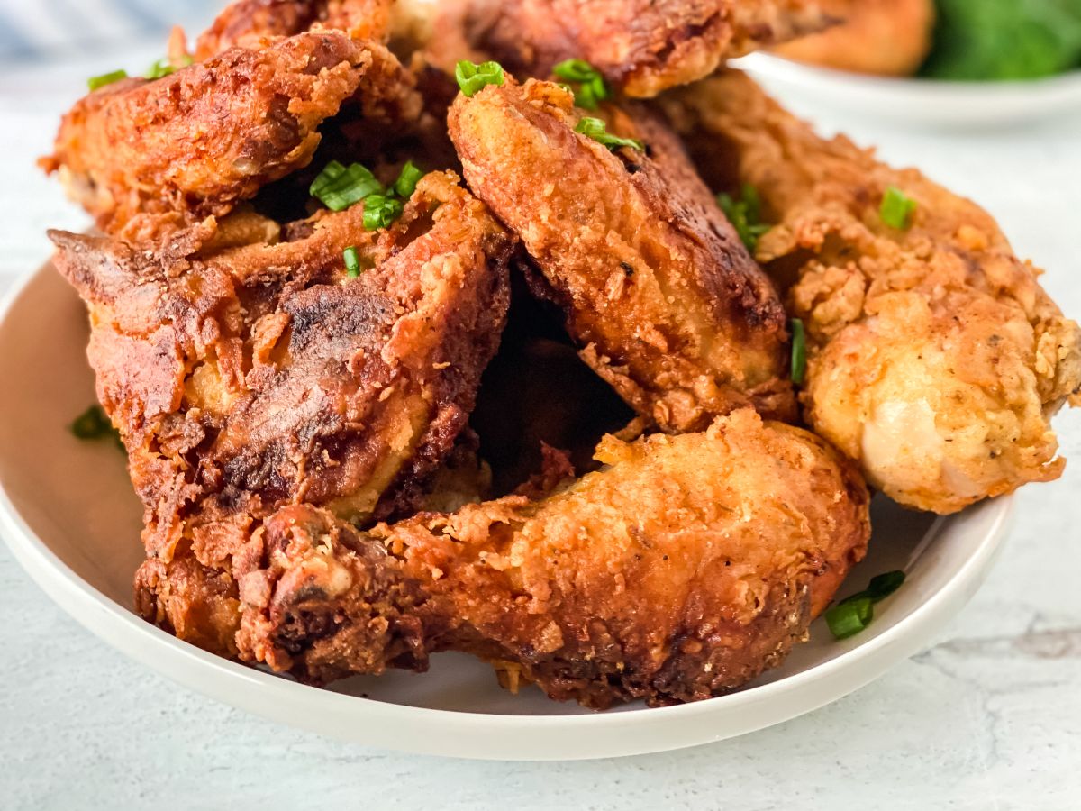 fried chicken stacked in large white bowl on table