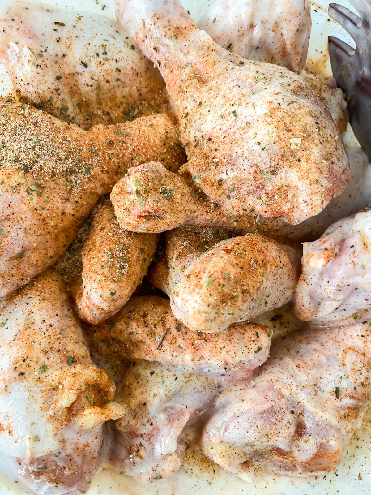 seasoned chicken pieces being put into bowl with milk