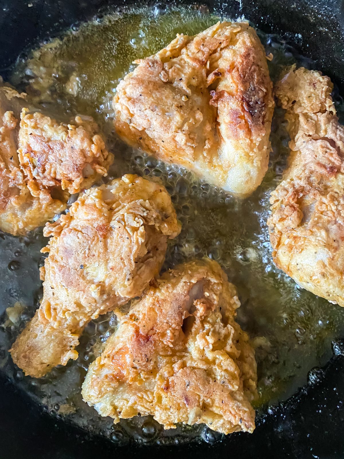 chicken in hot oil of cast iron skillet