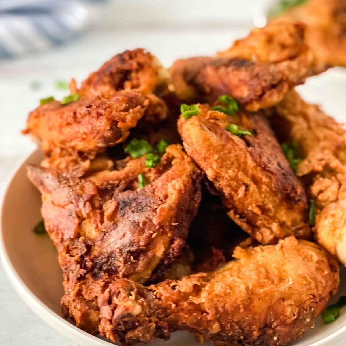 white bowl stacked with fried chicken wings