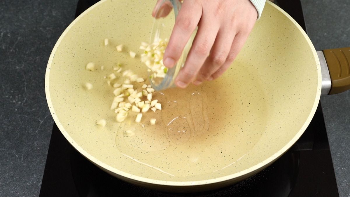 garlic being poured into skillet