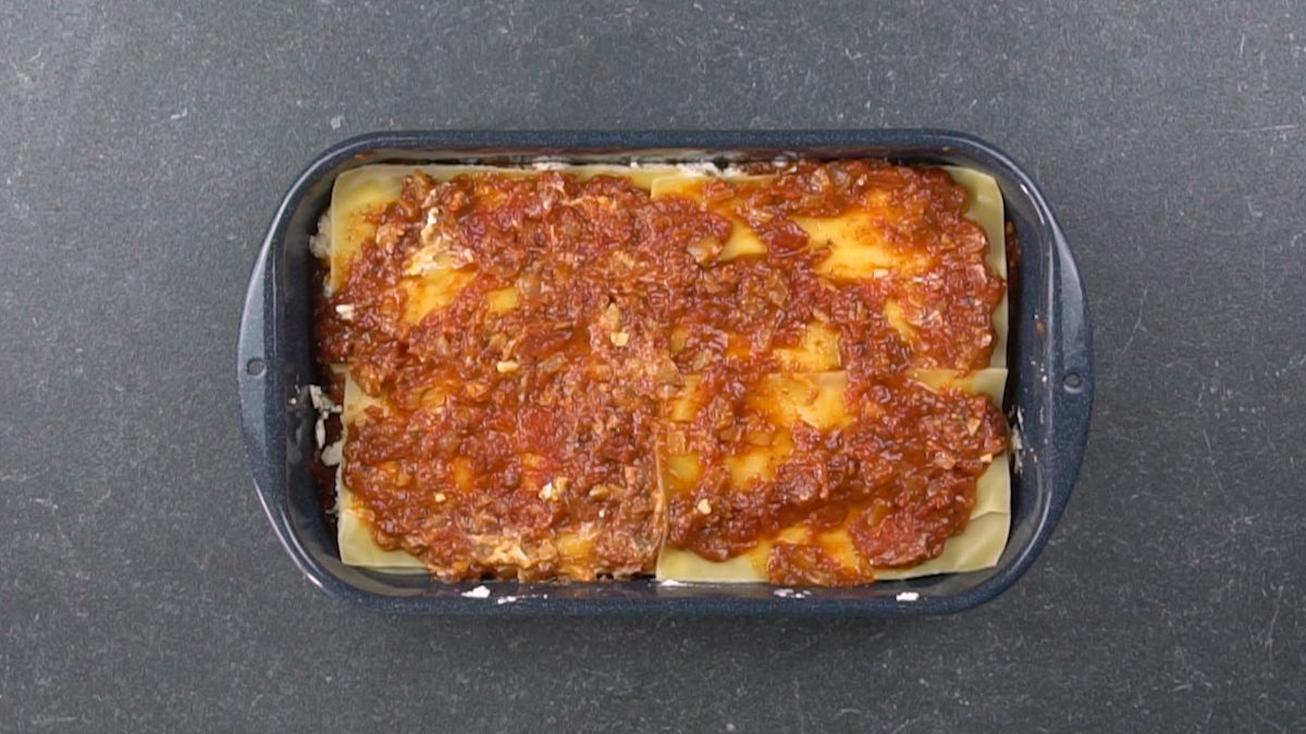 casserole filled with lasagna topped with tomato sauce