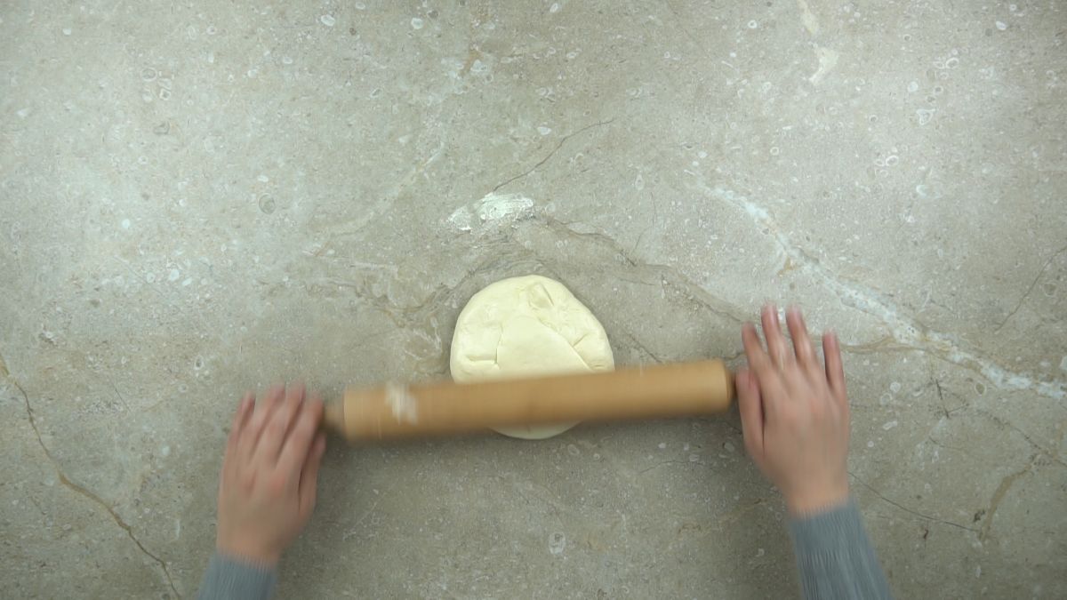 rolling pin on top of dough round