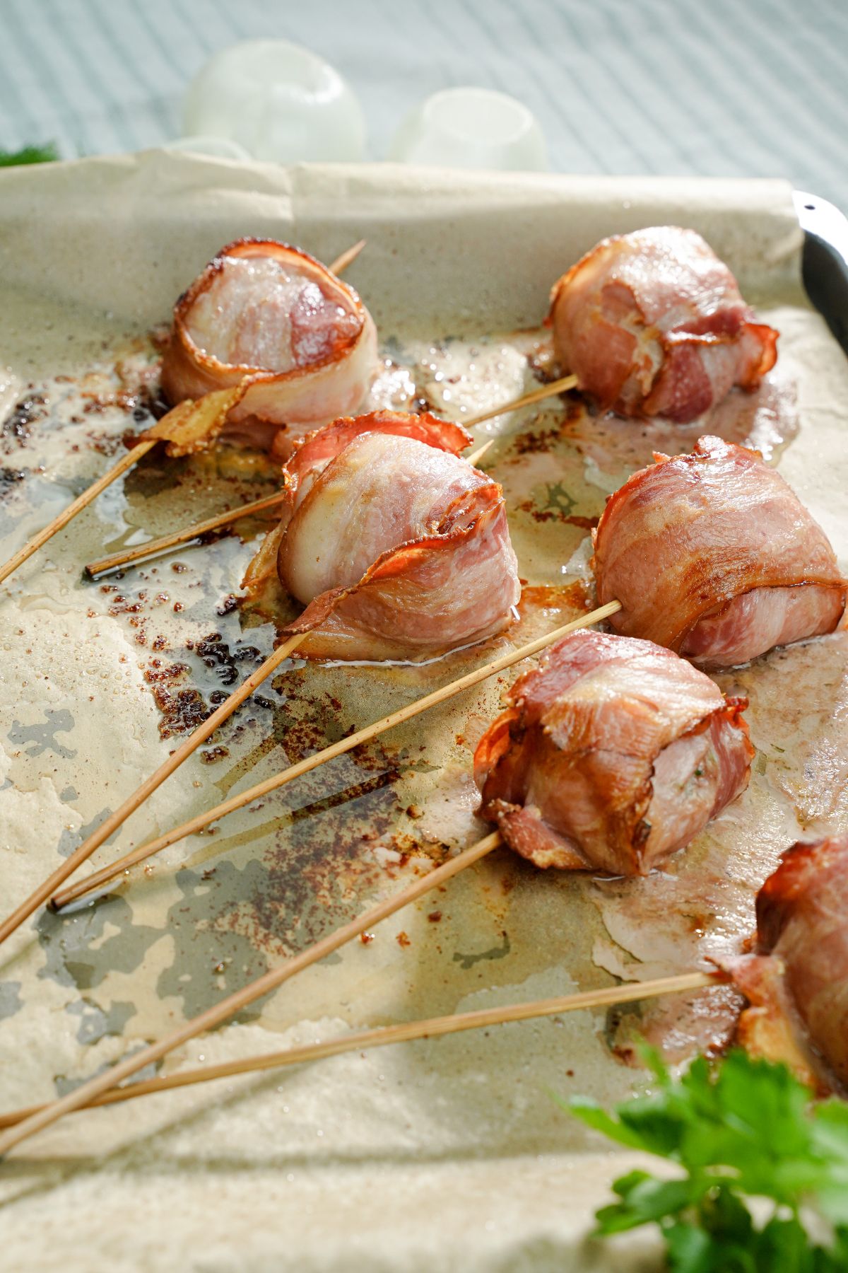bacon wrapped meatballs on parchment paper