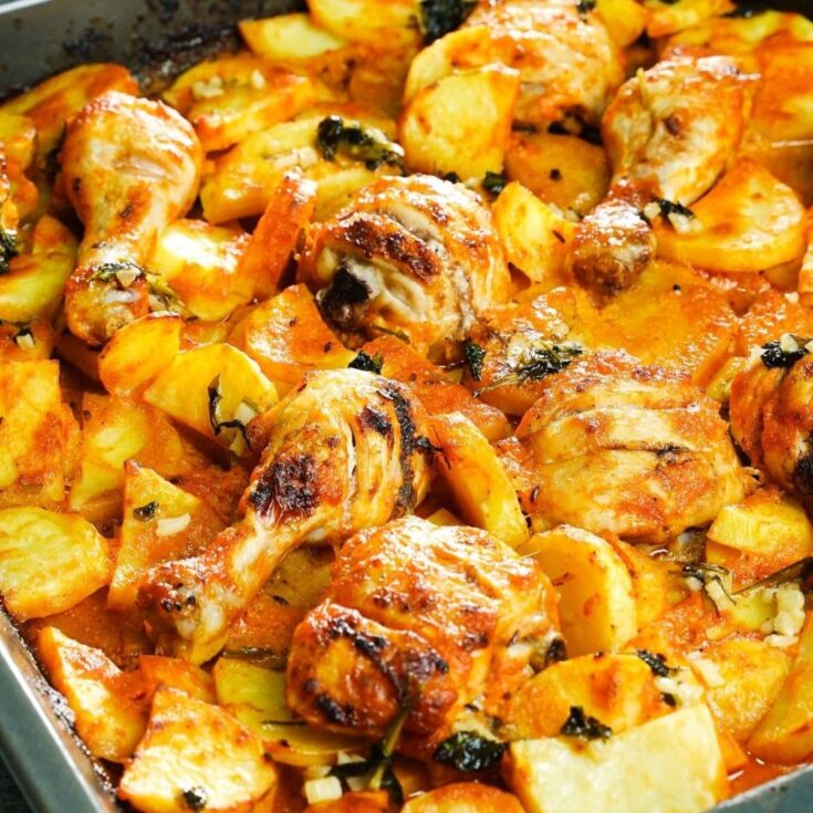 chicken legs on top of potatoes with sauce and browned on edges