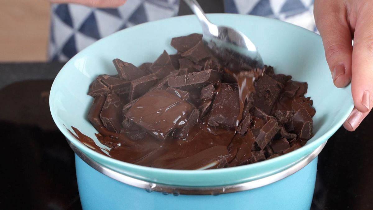 chocolate in blue bowl over saucepan