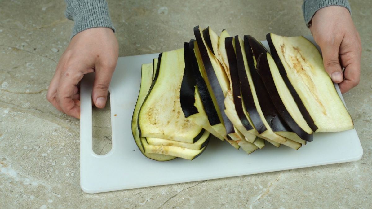 stack of eggplant slices on white cutting board