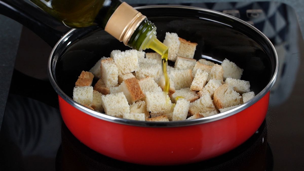 olive oil being poured over bread in skillet