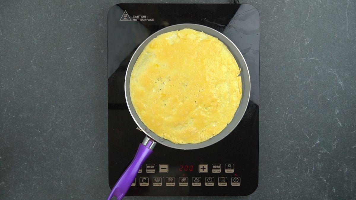 scrambled eggs in large skillet with purple handle