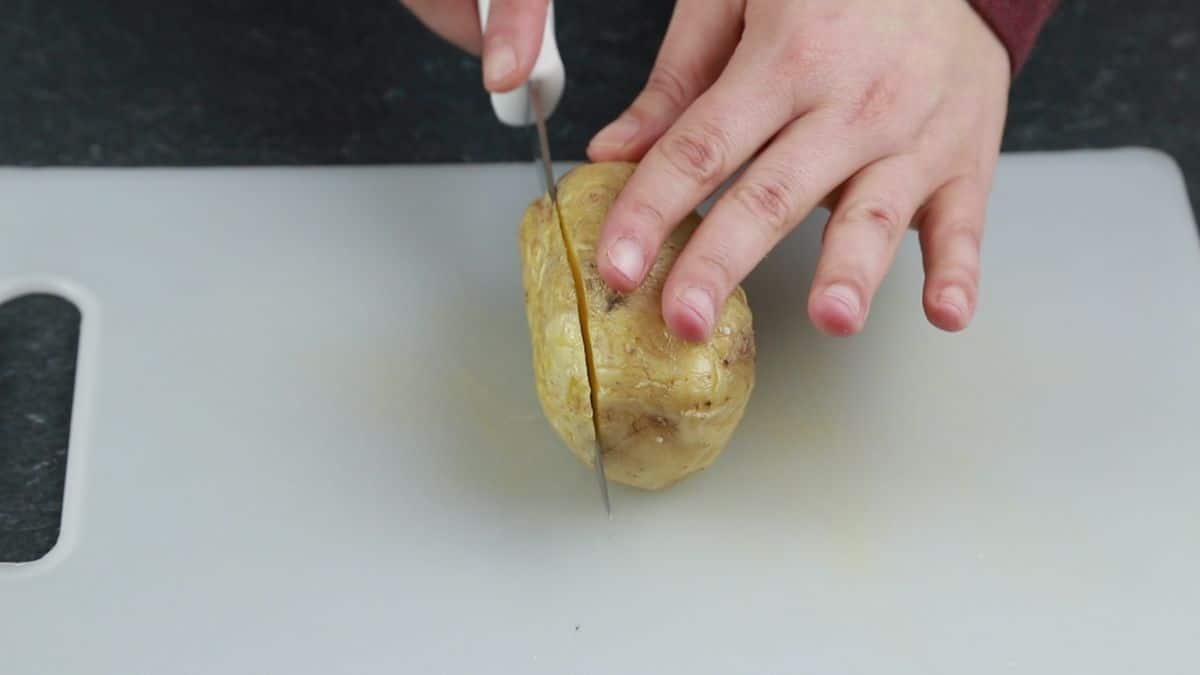 knife cutting top off of potato