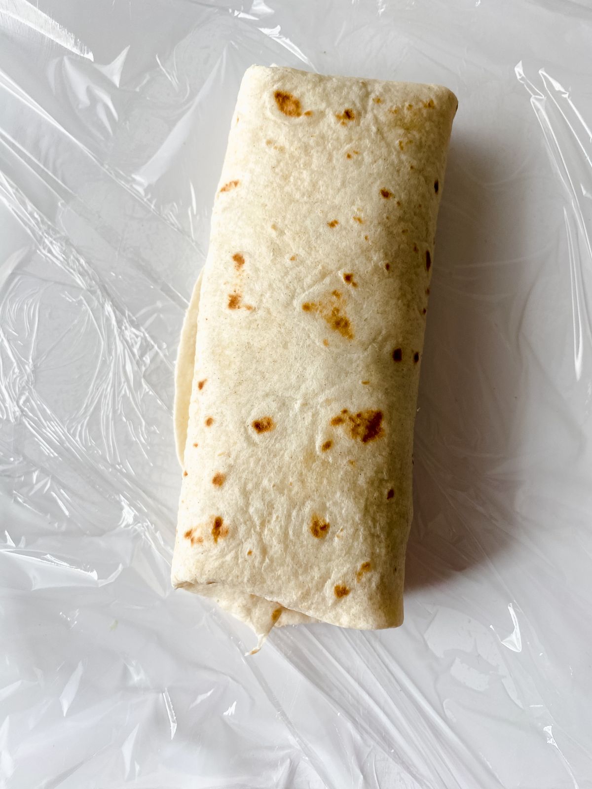 breakfast burrito on plastic wrap