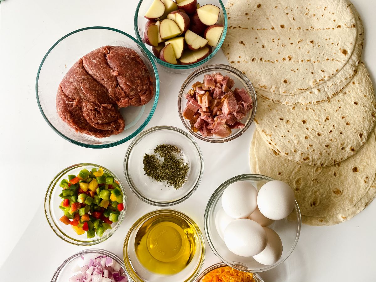 tortillas on white table with glass bowls of ingredients