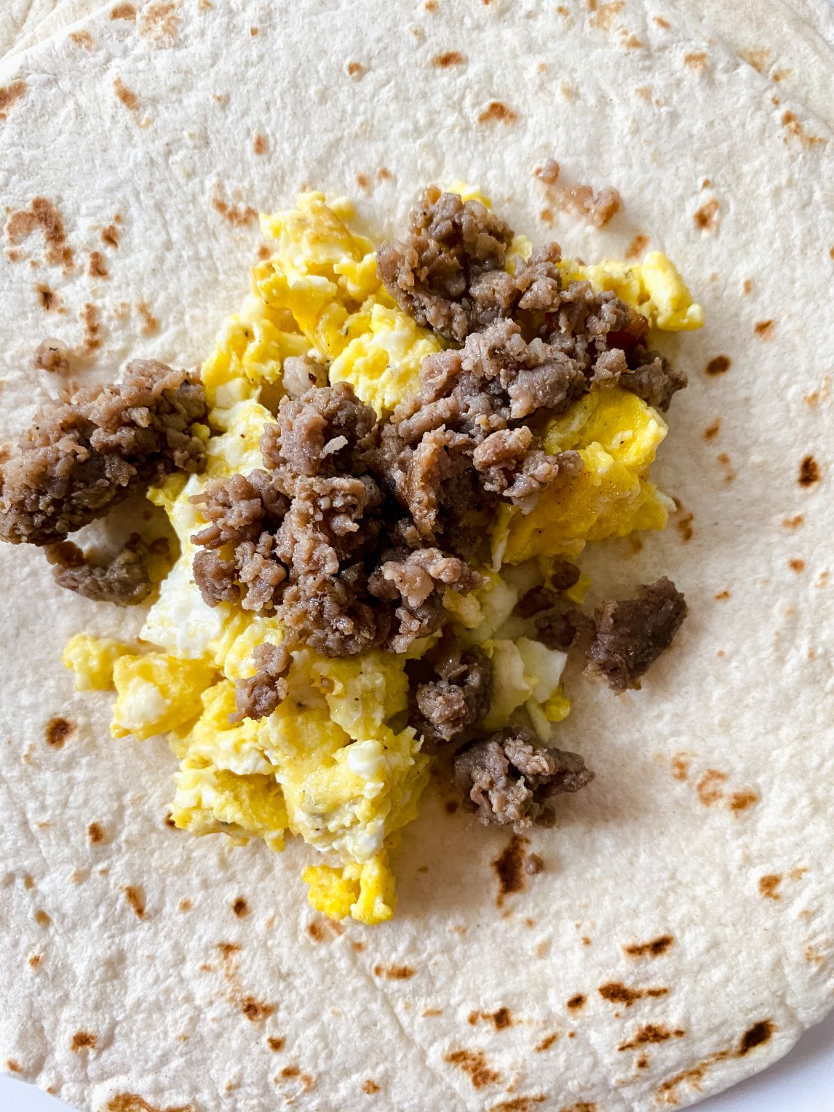eggs and sausage on middle of flour tortilla