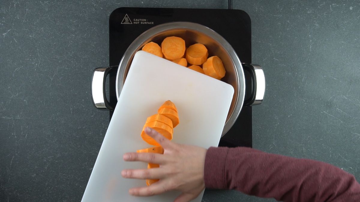 sweet potatoes being poured into saucepan