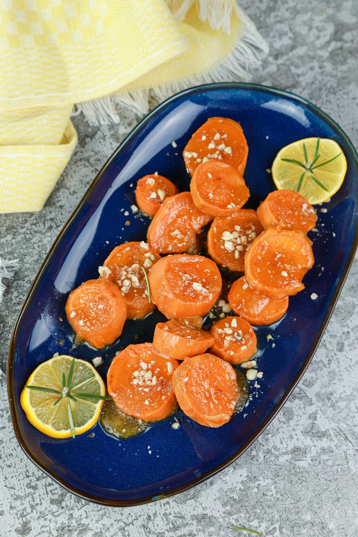 candied sweet potatoes on blue platter sitting on gray table