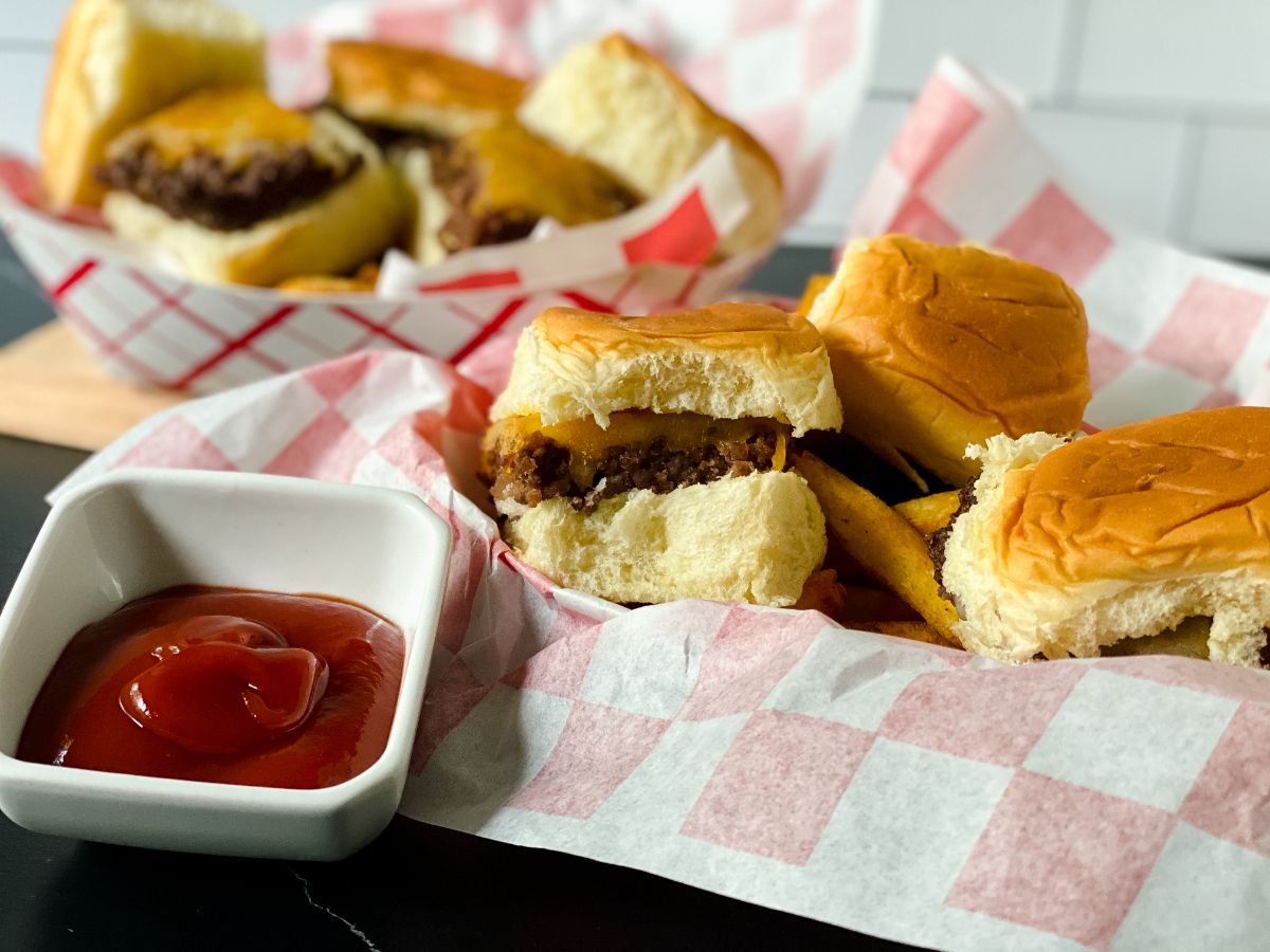 two baskets of sliders with checkered paper beneath the burgers