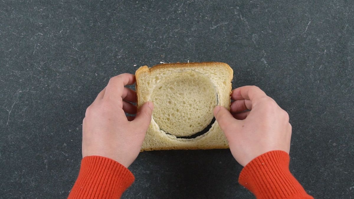hand pulling crust off bread