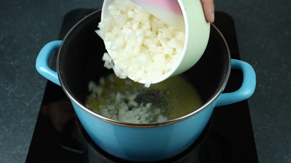 onions being poured into stockpot