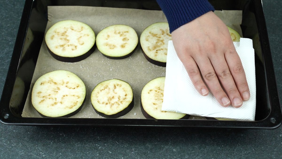 patting eggplant rounds with paper towel