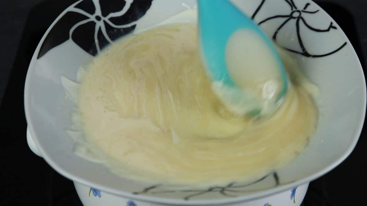 blue spoon stirring pudding in bowl