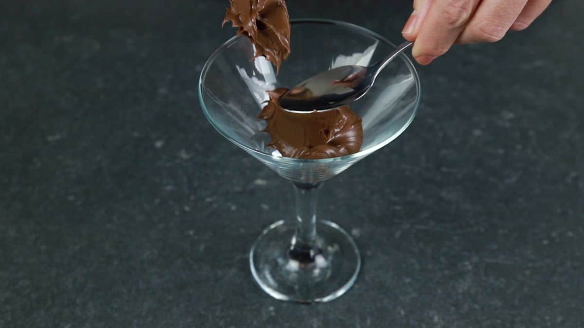 Nutella being spooned into martini glass