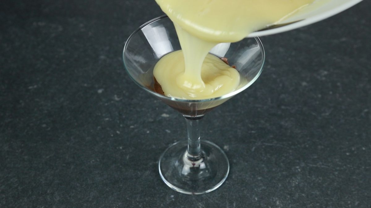 vanilla pudding being poured into dessert glass