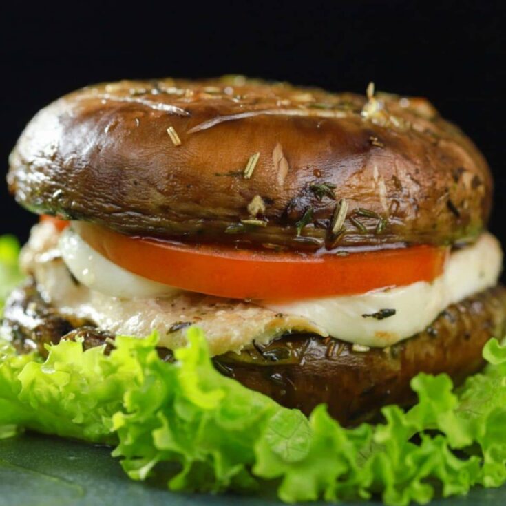 close up of a mushroom bun chicken burger on bed of lettuce