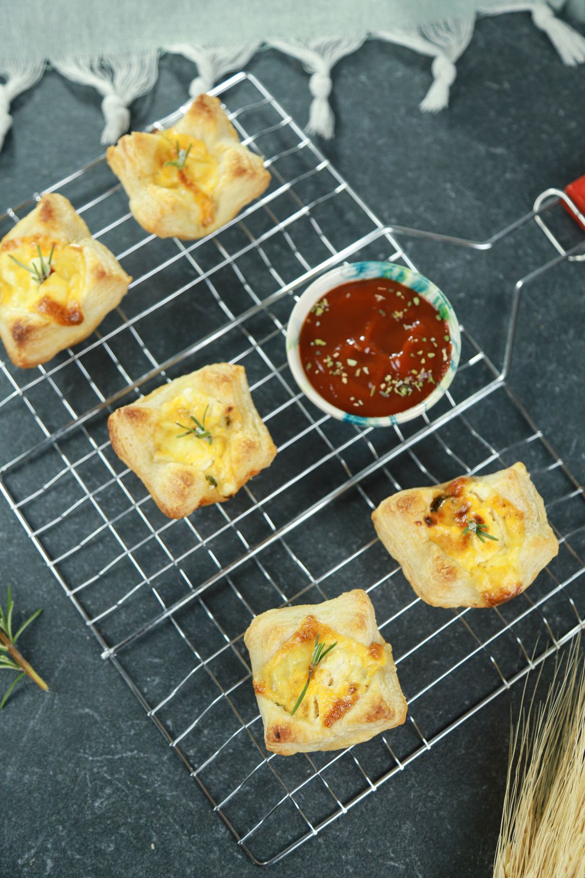 5 puff pastry quiches on wire rack with bowl of ketchup