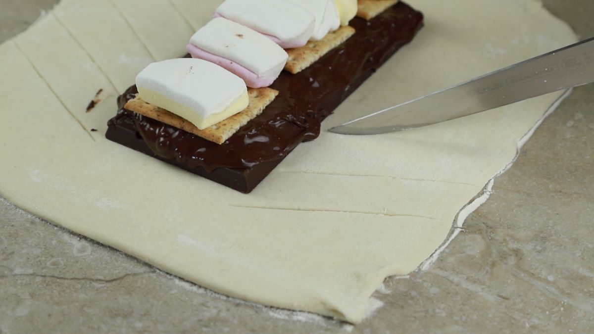 knife slicing dough by chocolate bar