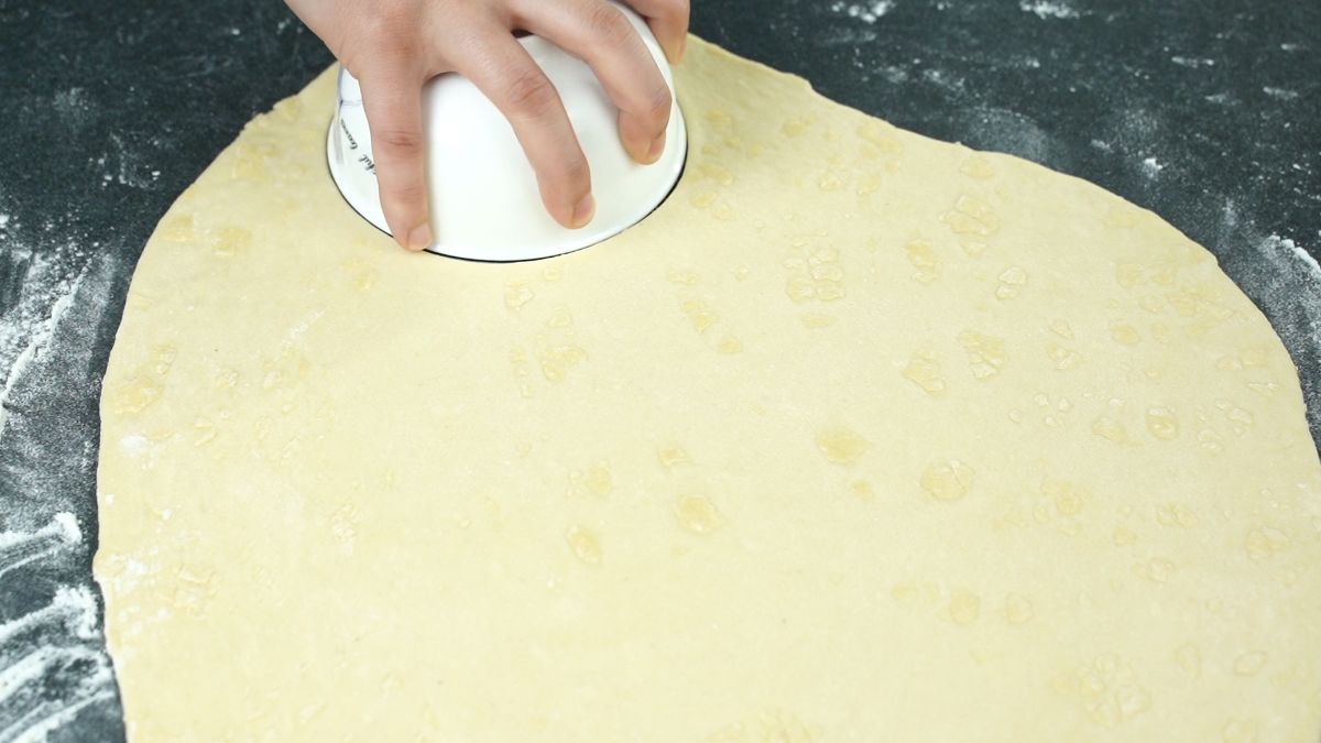 white bowl being used to cut dough rounds