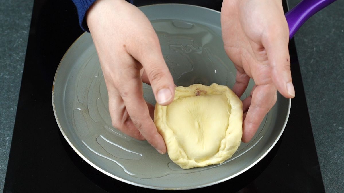 stuffed pancake being added to pan