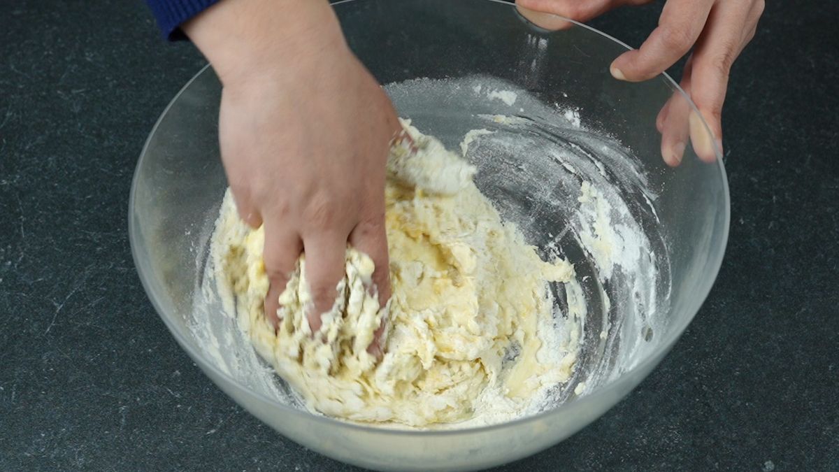 hand in glass bowl of dough